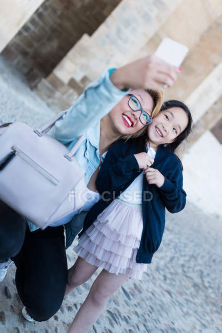 Счастливая молодая мать с дочерью, делающей селфи — стоковое фото