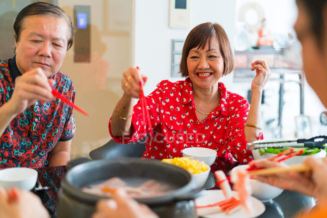 Щаслива азіатська сім'я їсть разом за столом — стокове фото