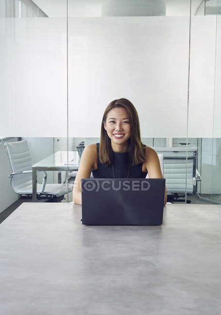 Junge asiatische Geschäftsfrau arbeitet mit Laptop im modernen Büro — Stockfoto