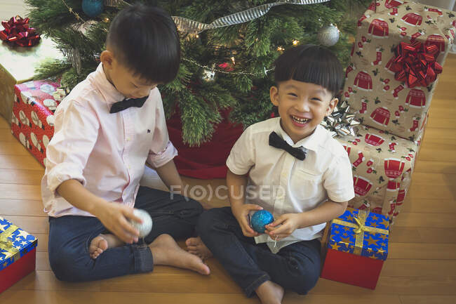 Hermanos jugando con la decoración del árbol de Navidad y divertirse. - foto de stock
