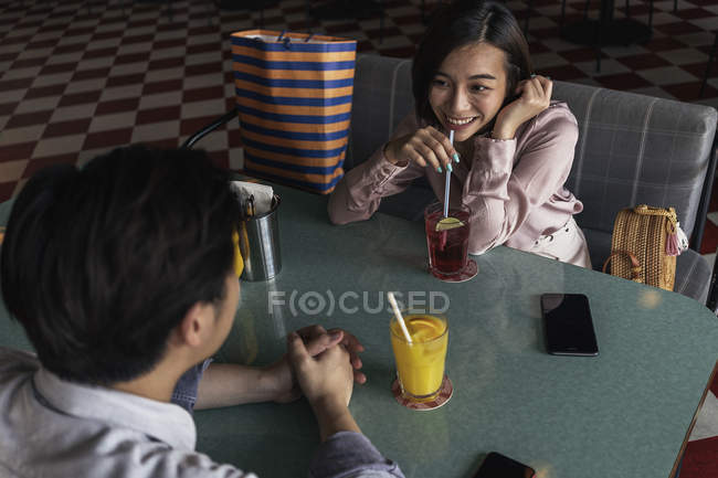 Joven asiático pareja pasando tiempo juntos en bar con bebidas - foto de stock