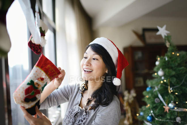 Famiglia asiatica che celebra le vacanze di Natale, casa decorare donna — Foto stock