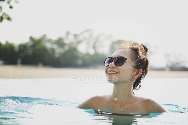 Gros plan vue de heureux belle asiatique femme natation dans piscine — Photo de stock