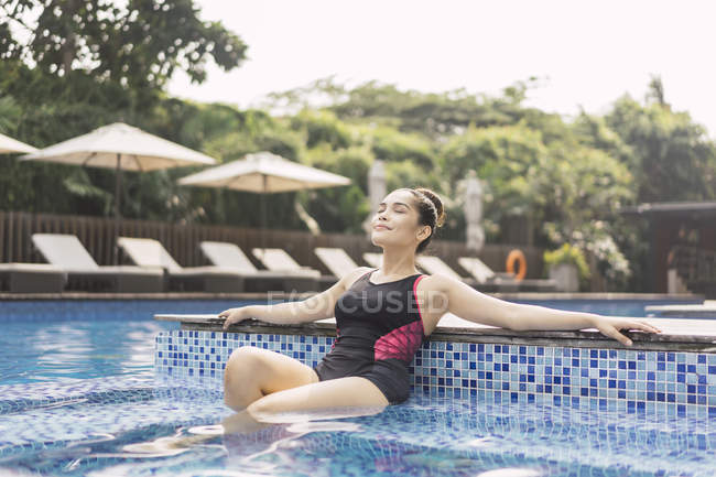 Junge schöne asiatische Frau in Badeanzug Spaß im Pool — Stockfoto