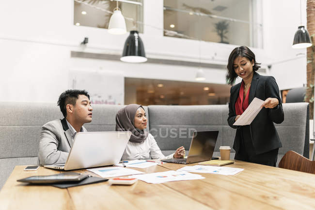Jovens empresários multiculturais em reunião de negócios em escritório moderno — Fotografia de Stock