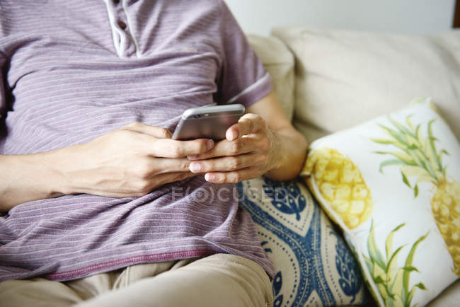 Обітнутого зображення людини за допомогою смартфона в домашніх умовах — стокове фото