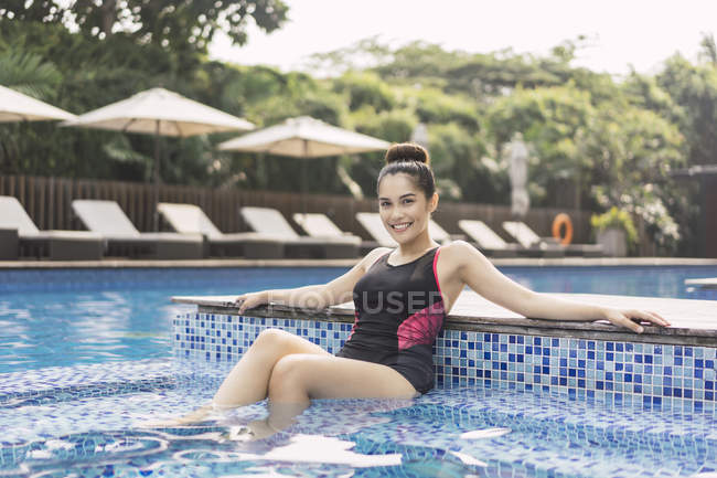 Jovem bela asiática mulher no natação terno ter diversão no piscina — Fotografia de Stock