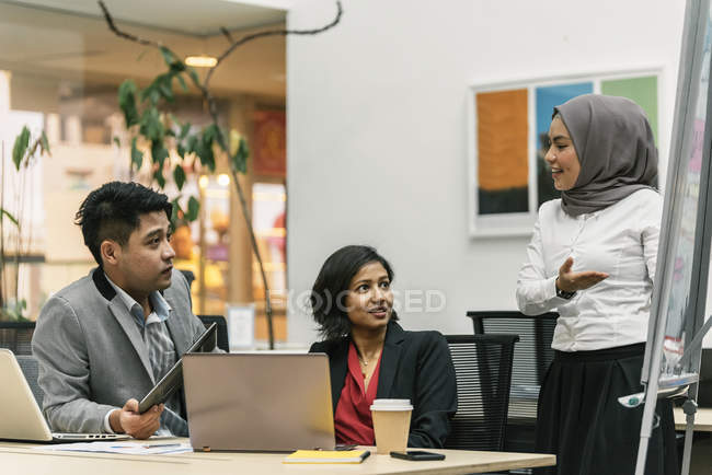 Jóvenes empresarios multiculturales que trabajan en oficinas modernas - foto de stock