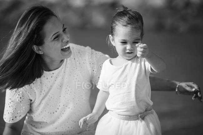 Mãe caucasiana feliz com filha na praia, imagem monocromática — Fotografia de Stock