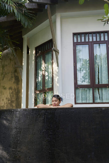 COMMUNIQUÉS Jeune femme asiatique se relaxant dans une piscine — Photo de stock