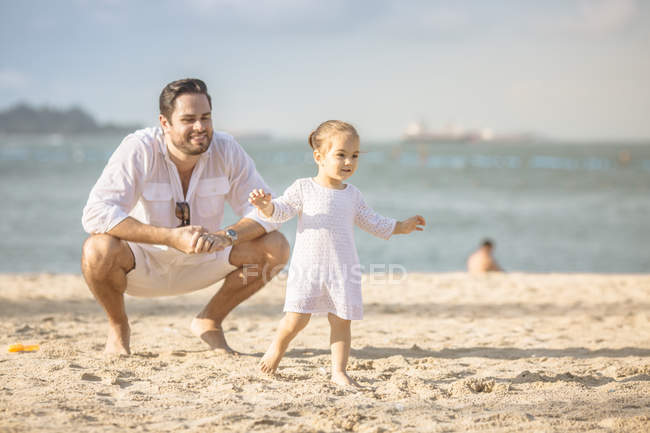 Família caucasiana feliz na praia, pai brincando com a filha — Fotografia de Stock
