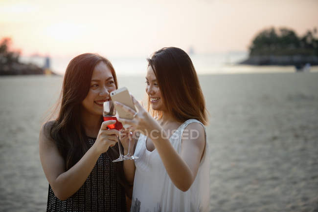 Hermosa joven asiático mujeres tomando selfie con vino - foto de stock