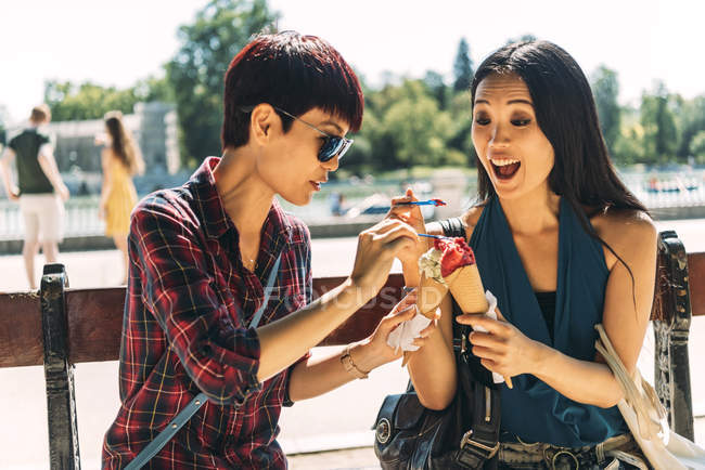 Mulheres asiáticas felizes comendo sorvete — Fotografia de Stock