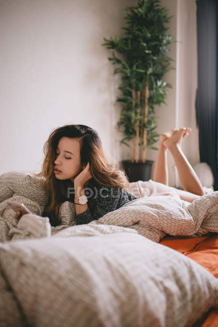 Jovem mulher descansando em sua cama no Japão — Fotografia de Stock