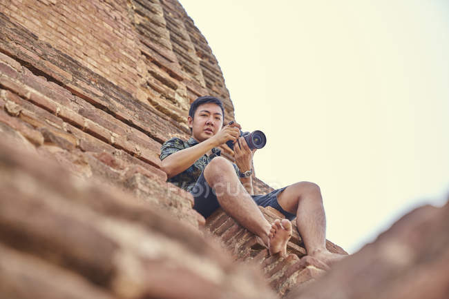 Jeune homme prenant une photo autour de l'ancien temple, pagode, Bagan, Myanmar — Photo de stock