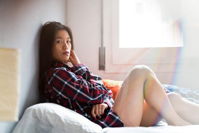 Junge attraktive asiatische Frau liegt im Bett — Stockfoto