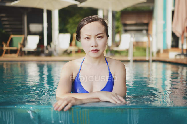Beautiful young asian woman relaxing in pool — Stock Photo