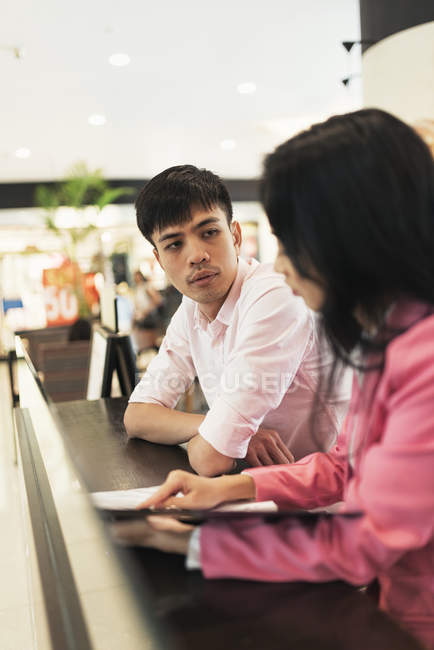 Attractive young asian couple sharing documents — Stock Photo