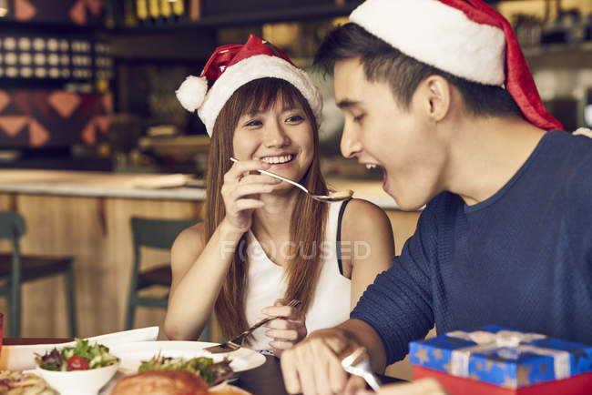 Casal de jovens asiáticos amigos juntos comer no Natal tabela — Fotografia de Stock