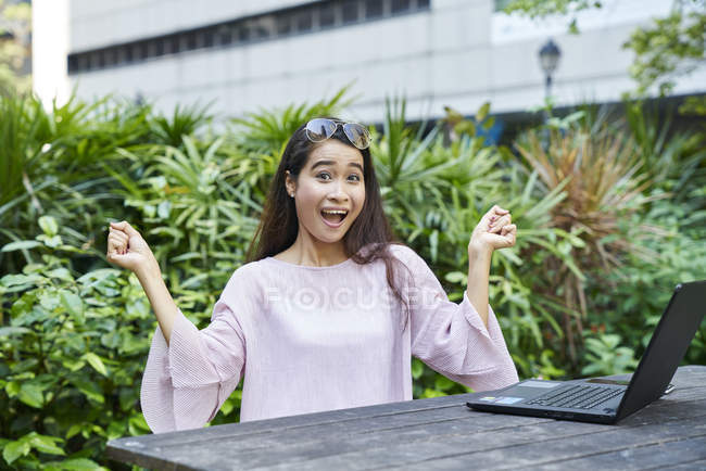Heureuse jeune dame malaise sur son ordinateur portable en plein air — Photo de stock