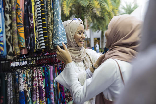 Due signore musulmane che fanno shopping per hijab . — Foto stock