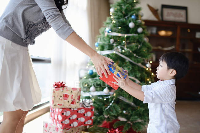 Asiático família celebrando Natal feriado, mãe dando presente ao filho — Fotografia de Stock