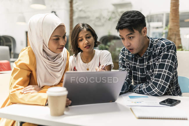 Young multicultural business people using laptop in modern office — Stock Photo