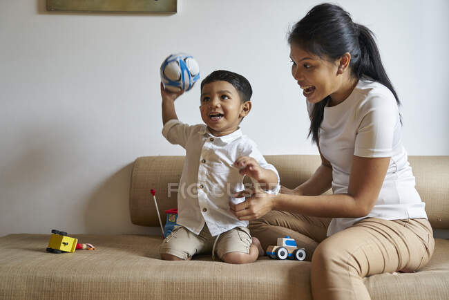 Мати і син зв'язуються над іграшками на дивані — стокове фото