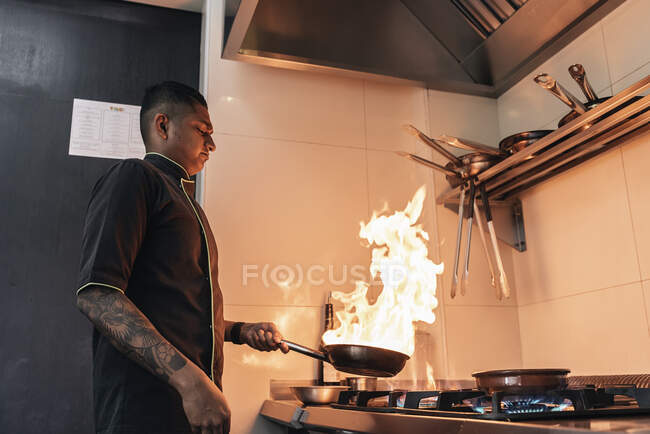 Jovem asiático chef cozinhar no restaurante cozinha — Fotografia de Stock