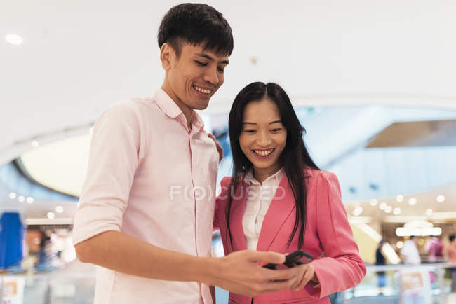 Atractivo joven asiático pareja usando smartphone juntos - foto de stock