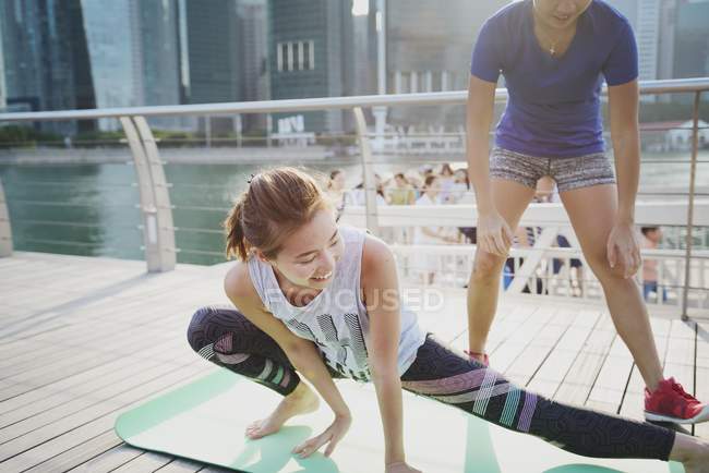 Remolque joven asiático mujeres estiramiento al aire libre - foto de stock