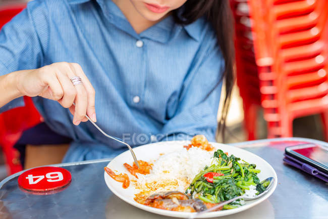 Attractive asian woman eating food at street cafe — Stock Photo