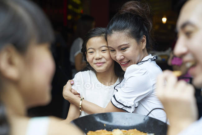Молодая счастливая азиатская семья ест пищу — стоковое фото