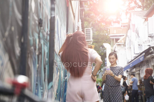 Молодые азиатские женщины фотографируют на городской улице — стоковое фото