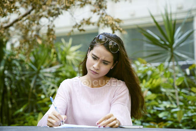 Young Malay lady frustrated with the documents she is looking through — Stock Photo