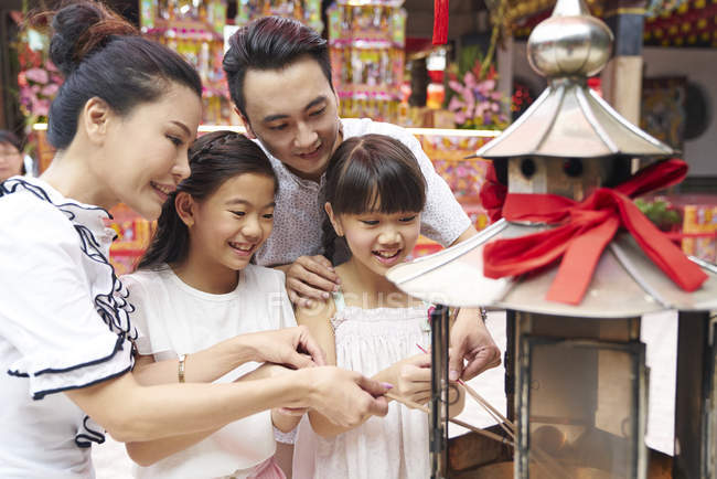 Young happy asian family at shrine, light lantern — Stock Photo