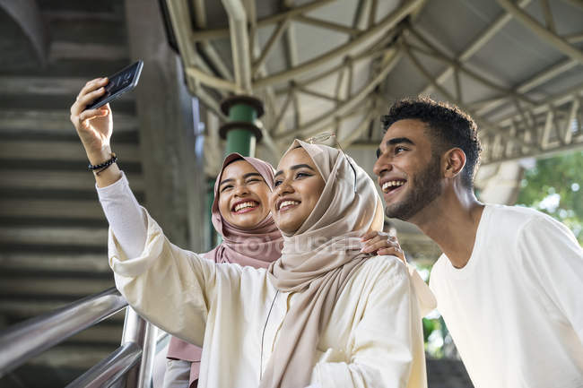 Група щасливих мусульманських друзів, які приймають селфі на смартфон — стокове фото