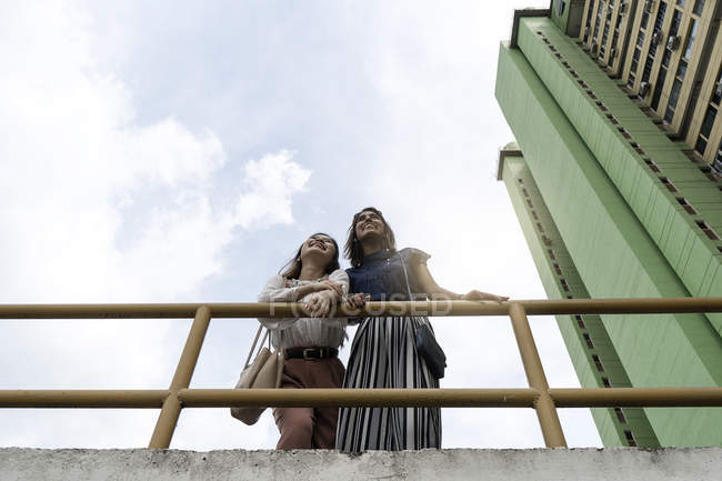 Jóvenes casual asiático niñas de pie en el techo - foto de stock