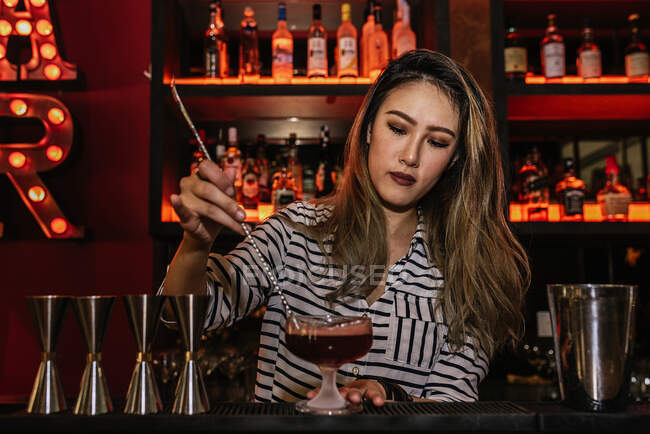 Портрет молодої жінки-бармена, що робить коктейль в барі — стокове фото