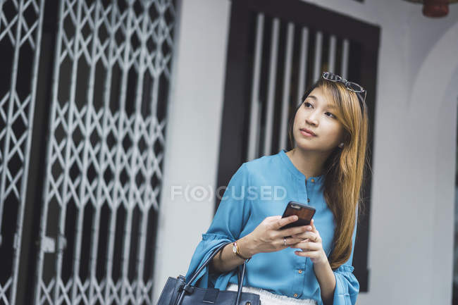 Приваблива молода азіатська дівчина використовує смартфон — стокове фото