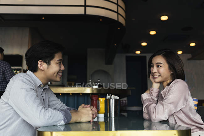 Young asian couple spending time together in bar — Stock Photo