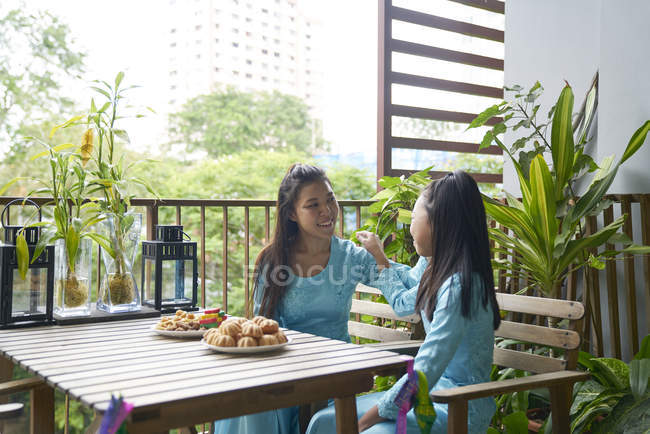 Young asian siblings eating at table together — Stock Photo