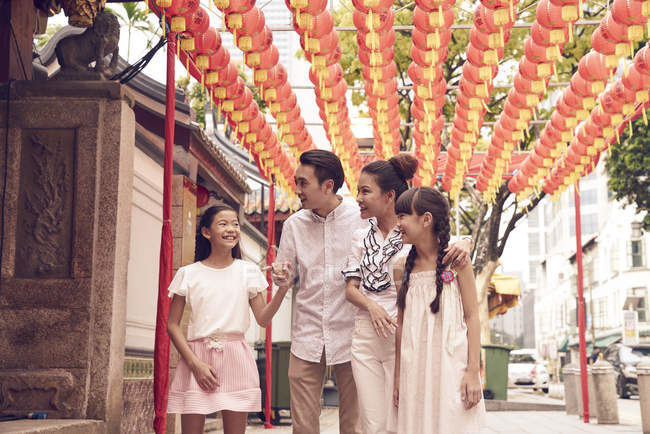 Young happy asian family in buddhish shrine — Stock Photo