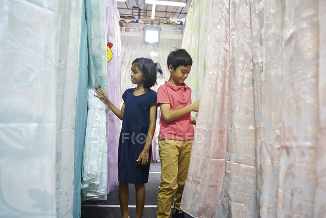 Брати і сестри купують штори під час Hari Raya Bazaar в Гейланзі (Сінгапур). — стокове фото