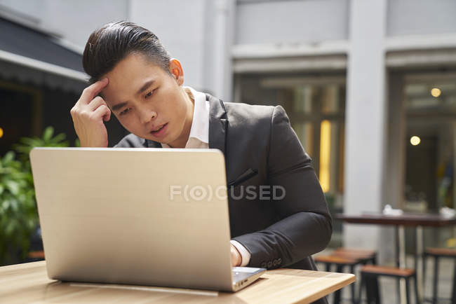 Young asian successful business man using laptop — Stock Photo