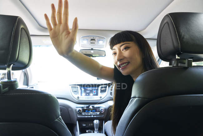 Весела жінка водій дає своєму пасажиру привіт-п'ять — стокове фото
