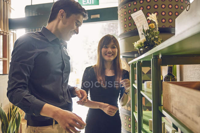 Couple of young asian friends together choosing wine in shop — Stock Photo