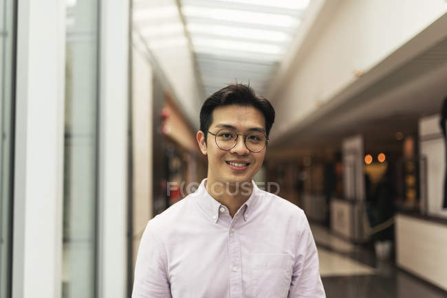 Young casual asian man at shopping mall — Stock Photo