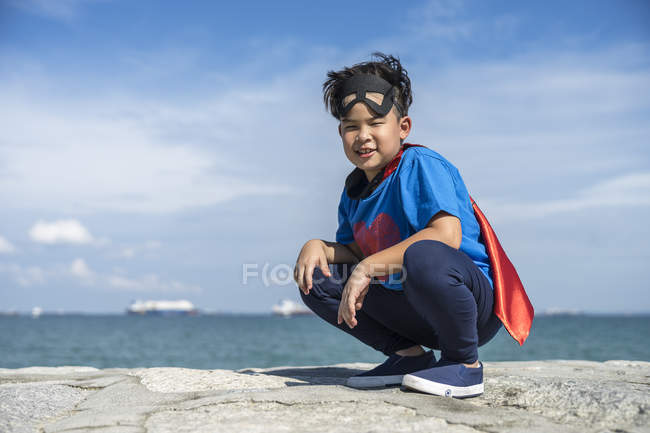 Portrait of superhero kid squatting down. — Stock Photo