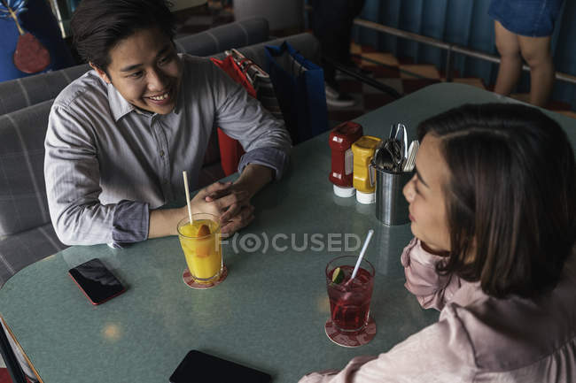 Young asian couple spending time together in bar — Stock Photo